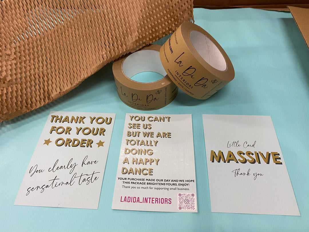 Eco friendly paper packaging, blue tissue paper and thank you cards with rolls of paper parcel tape
