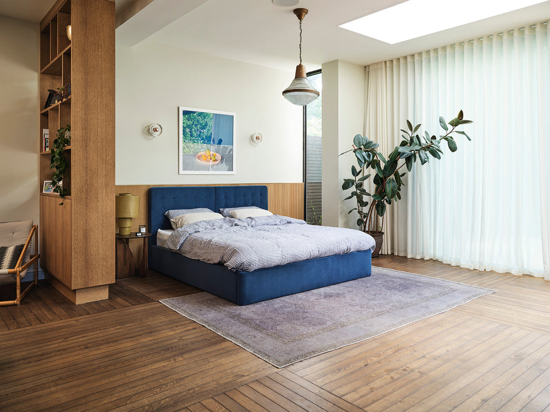 Swyft Bed 01 in blue with wooden floor and large plant next to window