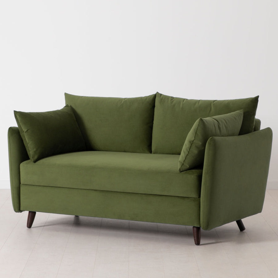 Swyft Model 08 2 seater sofa bed in green velvet at an angle on white background