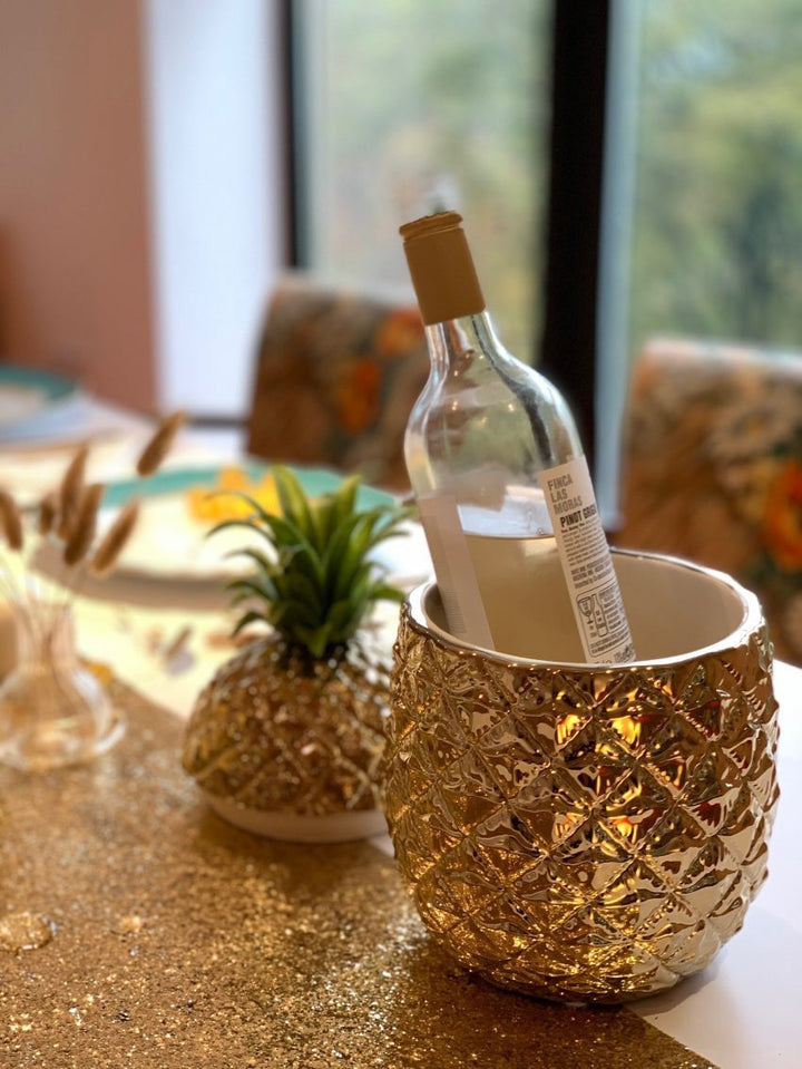 Pineapple ice bucket with wine bottle on a table